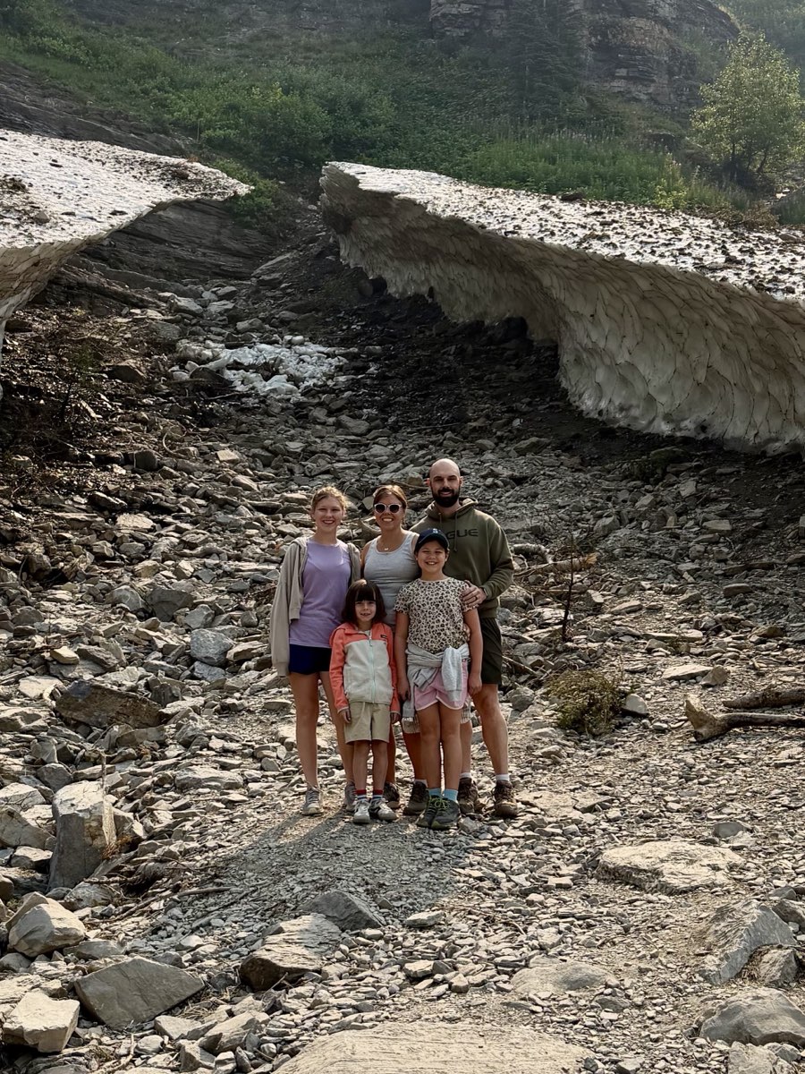 Alex Barrett and family hiking beneath a mountain snow bridge